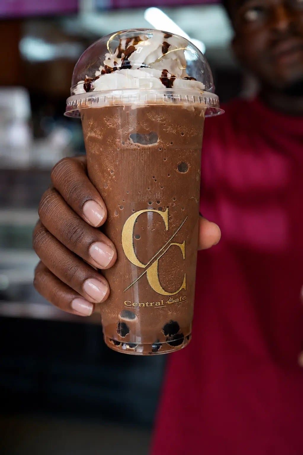 A chocolate boba shake with cream and chocolate drizzle