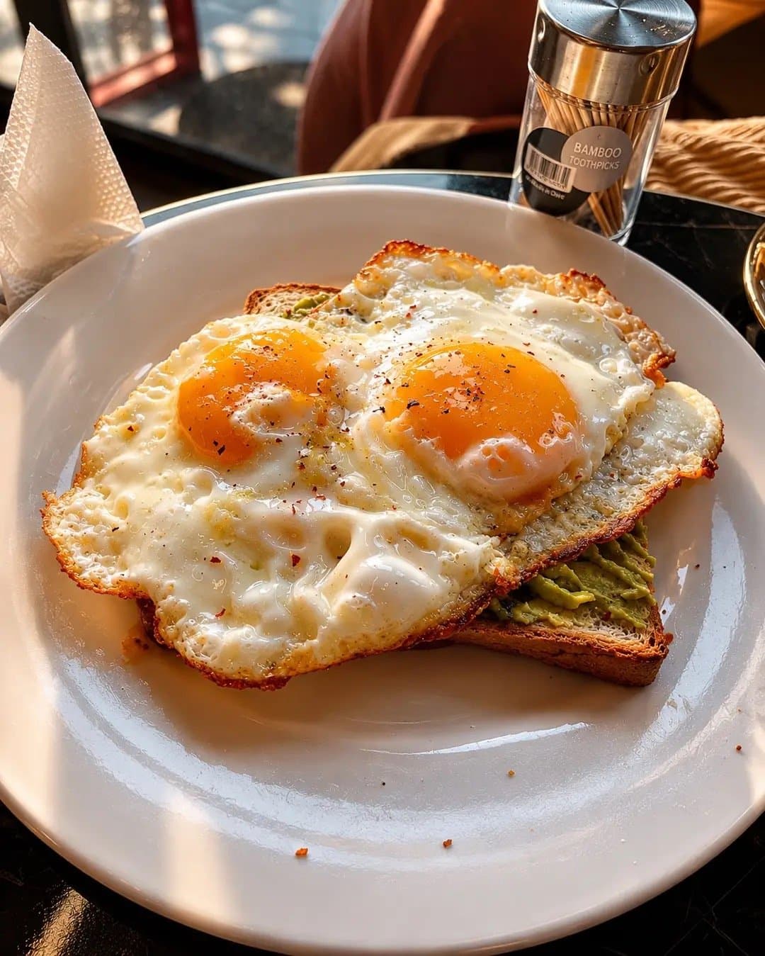 Two fried eggs on avocado toast