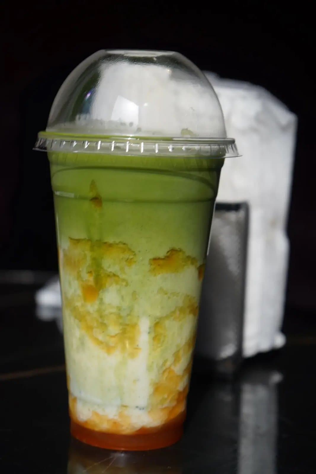 A mango matcha: green matcha over milk over mango