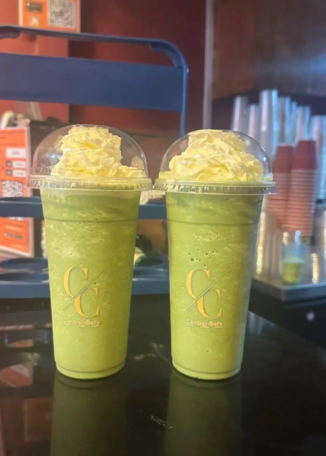 Two matcha frappés topped with cream