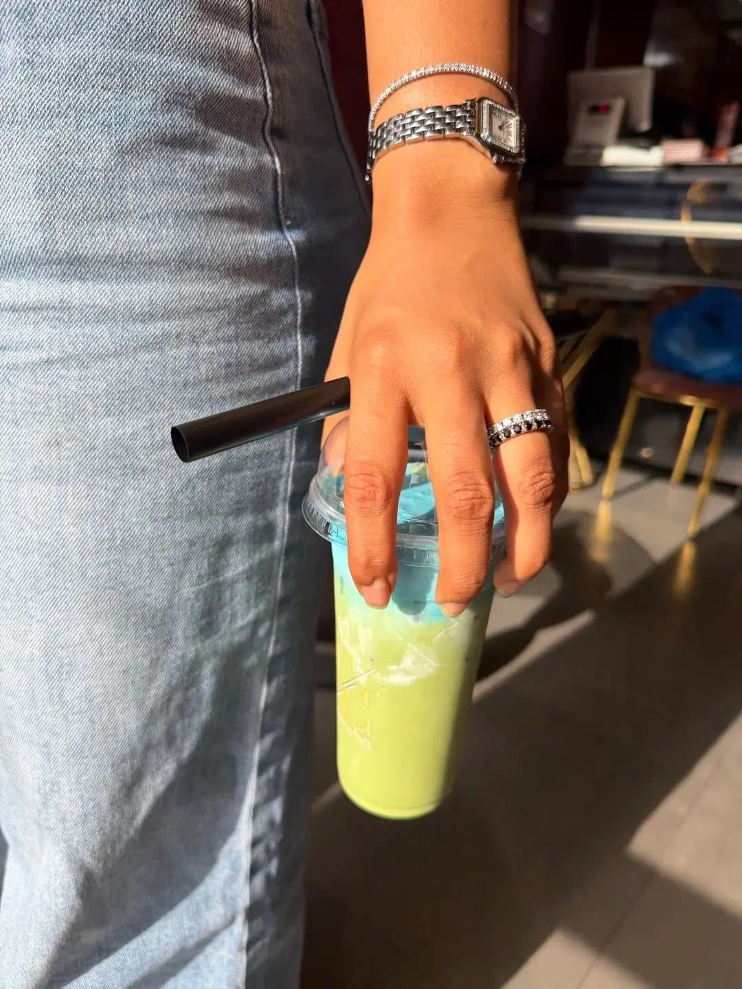 A customer holding a matcha drink inside the cafe