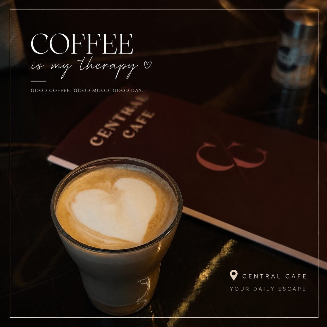 A flat white beside the Central Cafe menu on a dark marble table